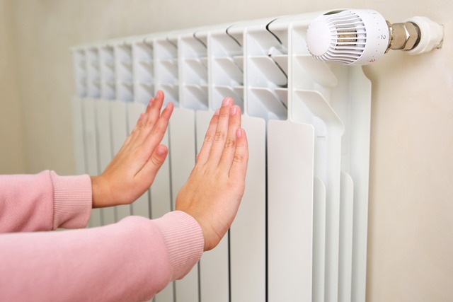 The Child Warms His Hands Near The Heater.